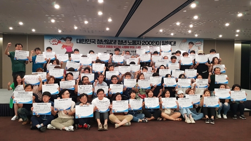 20일 '청년 노동자 대토론회'에 참가한 청년 노동자들이 피켓에 '가장 시급한 노동문제'를 적어 들어 보이고 있다. [사진=연합뉴스]