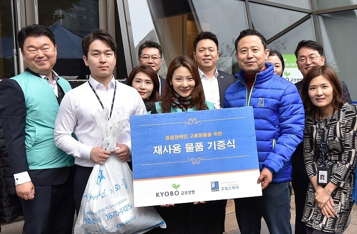 15일 오후 광화문 교보생명 본사에서 열린 ‘함께하는 나눔 캠페인’ 자선 바자회에서 교보생명 임직원들과 윤성우 밀알복지재단 나눔사업부장(오른쪽 두번째)이 재사용 물품 기증식 기념사진을 촬영하고 있다. (사진=교보생명)