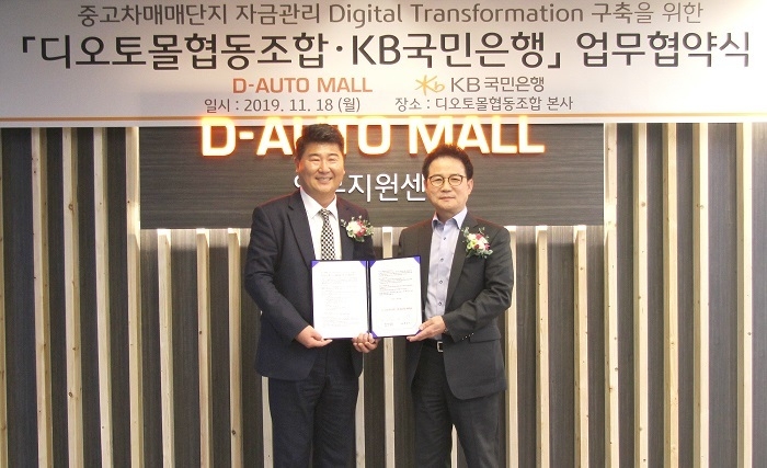 지난 18일, 대전시 유성구 디오토몰 자동차복합매매단지에서 열린 '중고차 매매단지 자금관리 디지털 트랜스포메이션 구축을 위한 업무협약식'에서 참석자들이 기념촬영을 하고 있다. (왼쪽부터) 백승호 디오토몰협동조합 이사장, 신덕순 KB국민은행 중소기업고객그룹 대표. (사진=KB국민은행)