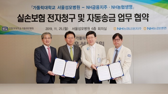 김광수 NH농협금융지주 회장(왼쪽 두 번째)과 홍재은 NH농협생명 대표(왼쪽 첫 번째)가 25일 서울성모병원에서 열린 ‘실손보험금 전자청구 활성화’ 업무 협약식에서 병원 관계자들과 기념촬영을 하고 있다. (사진=농협금융지주)