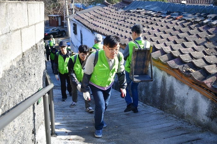 이원삼 IT부문 부행장(사진 맨 앞)을 비롯한 NH농협 IT사랑봉사단원들이 27일 성북구 정릉3동에서 연탄을 배달하고 있다. (사진=NH농협은행)