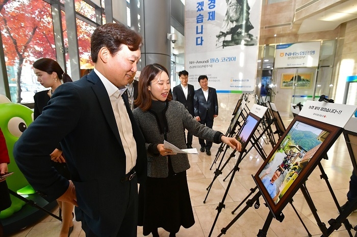 서윤성 소비자보호부문 부행장과 임직원들이 서울 중구에 위치한 농협은행 본점 로비에서 '즐거운 일터 사진 전시회'에 출품된 작품들을 관람하고 있다. (사진=NH농협은행)