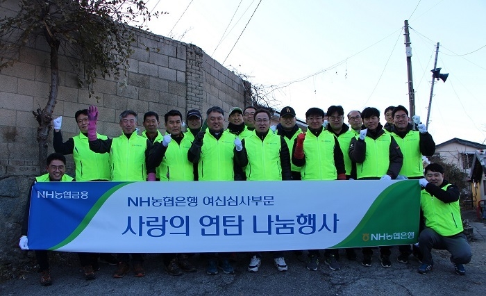 NH농협은행 여신심사부문 송수일 부행장(앞줄 가운데)과 봉사단원들이 4일 노원구 상계 3동과 4동을 찾아 ‘사랑의 연탄 나눔’ 기념촬영을 하고 있다. (사진=NH농협은행)