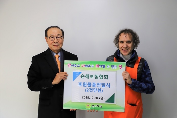 손해보험협회 김용덕 회장(왼쪽)이 안나의 집 김하종 신부(오른쪽)에게 후원물품을 전달하고 있다. (사진=손보협회)