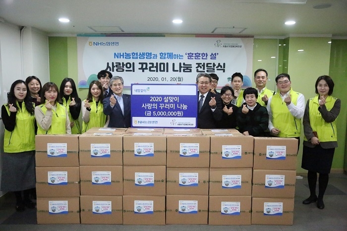 홍재은 농협생명 대표이사(왼쪽 7번째)와 고영훈 서울시각장애인복지관 관장(오른쪽 8번째)을 비롯한 농협생명 봉사자들이 지난 20일 ‘훈훈한 설’ 사랑의 꾸러미 나눔 전달식을 기념해 하트를 만들고 있다. (사진=농협생명) 