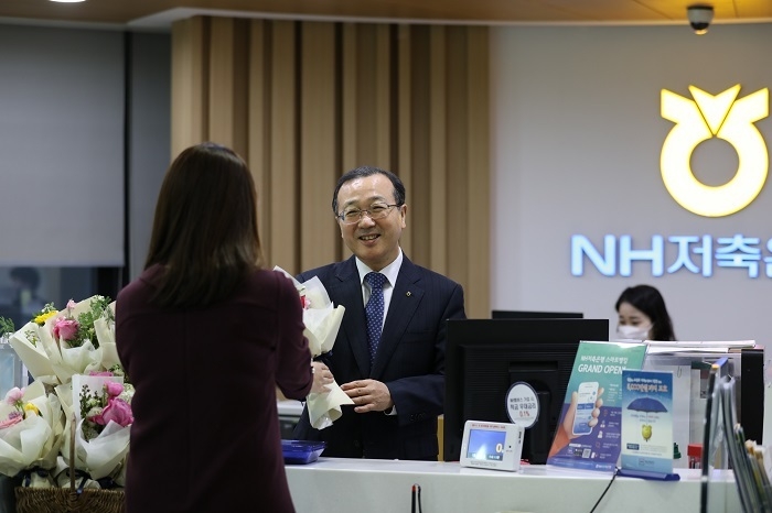 지난 14일, 서울 강남구 소재 NH저축은행 본점영업부에서 실시한 ‘꽃 나눔 행사’에서 김건영 대표이사(사진 가운데)가 영업점 내방고객에게 꽃을 나눠주고 있다. (사진=NH저축은행)