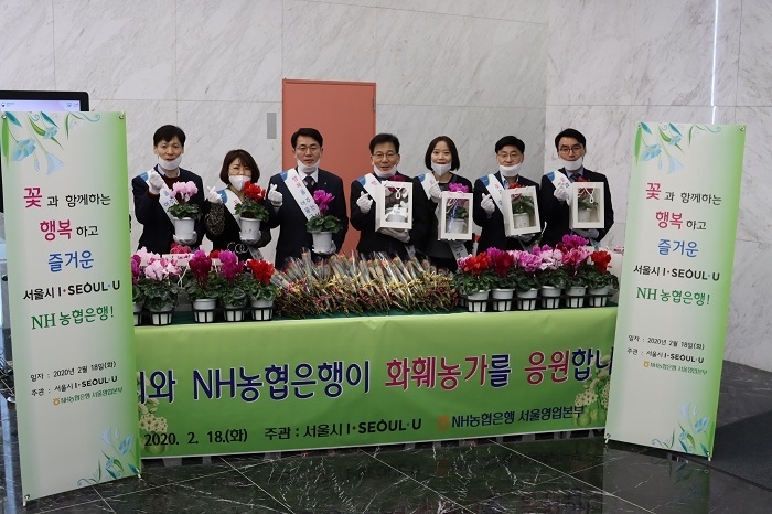 이석용 농협은행 서울영업본부장(사진 왼쪽에서 세 번째)과 송인봉 서울시 도시농업과장(사진 왼쪽에서 네 번째)이 꽃 나눔 행사를 전개하기 전 농협은행 서울영업본부 임직원들과 기념촬영을 하고 있다. (사진=농협은행)