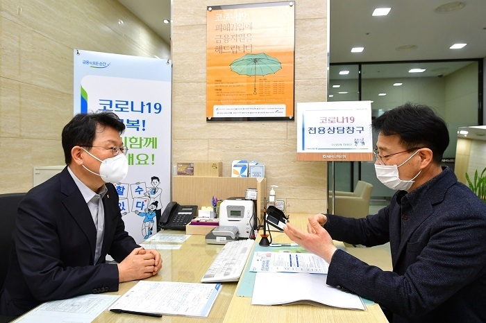 지난 5일, 서울 중구 소재 농협은행 본점 영업부에 마련된 ‘코로나19 피해기업 전용 상담창구’ 에서 김광수 농협금융 회장(사진 왼쪽)이 일일 상담원으로서 코로나19 피해 소상공인의 애로사항을 청취하고, 금융 상담을 하고 있다. 