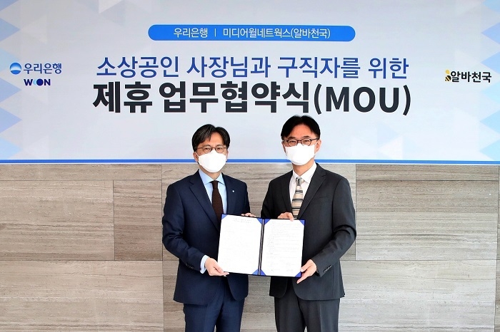 우리은행은 지난 16일 우리은행 본점에서 알바천국을 운영중인 ㈜미디어윌네트웍스와 '소상공인 사장님과 구직자를 위한 제휴 업무협약'을 체결했다. 황원철(왼쪽) 우리은행 디지털금융그룹 상무가 공선욱 미디어월네트웍스 대표와 기념촬영을 하고 있다. (사진=우리은행)