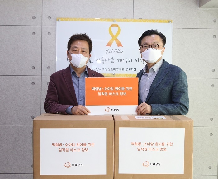 김영식 한화생명 홍보실장(오른쪽)과 정영기 한국백혈병소아암협회 경인지회 지회장(왼쪽)이 캠페인으로 모인 보건용 마스크 3208장앞에서 기념촬영을 하고 있다. (사진=한화생명)