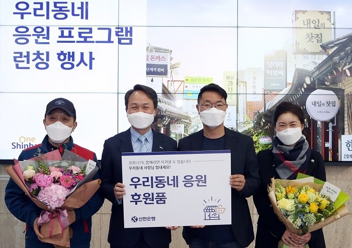 22일 서울 중구에 위치한 신한은행 본점 1층 로비에서 가진 ‘우리동네 응원 프로그램’ 론칭 행사에서 ‘우리동네 응원 후원품’을 증정한 후 진옥동 신한은행장(왼쪽에서 두번째)이 인근지역 소상공인 대표들과 기념촬영 하는 모습. (사진=신한은행) 