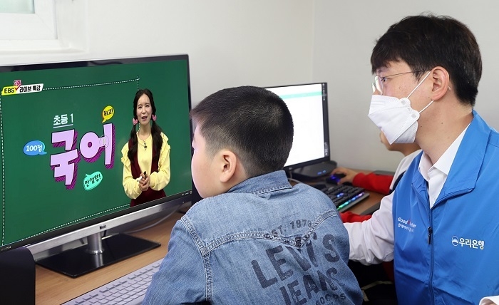 우리금융은 코로나19 장기화로 온라인개학을 했지만, 학습기기 부족으로 수업에 어려움을 겪고 있는 취약계층 아동을 돕기 위해 전국 410개 그룹홈에 컴퓨터 및 교육 컨텐츠 지원, 보조교사 파견 등을 지원한다. 우리금융 자원봉사단원이 그룹홈 아동과 함께 그룹홈 공부방에서 온라인 수업을 듣고 있는 모습. (사진=우리금융)