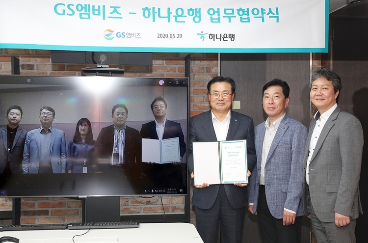 하나은행은 지난 29일 오후 자동차 종합 서비스 기업 GS엠비즈㈜와 ‘자동차 생활 금융서비스’를 위한 전략적 업무 협약을 체결했다. 정석화 하나은행 리테일그룹장(사진 오른쪽 세 번째)이 서울 중구 을지로 소재 하나은행 본점에서 김철민 GS엠비즈 전무(오른쪽에서 네 번째)와 화상 영상을 통해 업무 협약 체결 후 기념사진 촬영을 하고 있다. (사진=하나은행)