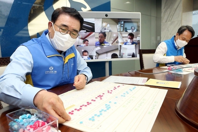 조용병 신한금융 회장(사진 왼쪽)과 진옥동 신한은행장이 지난 17일 본사 집무실에서 ‘시각장애인을 위한 점자 교보재 만들기’ 봉사활동에 직접 참여하고 있는 모습. (사진=신한금융)