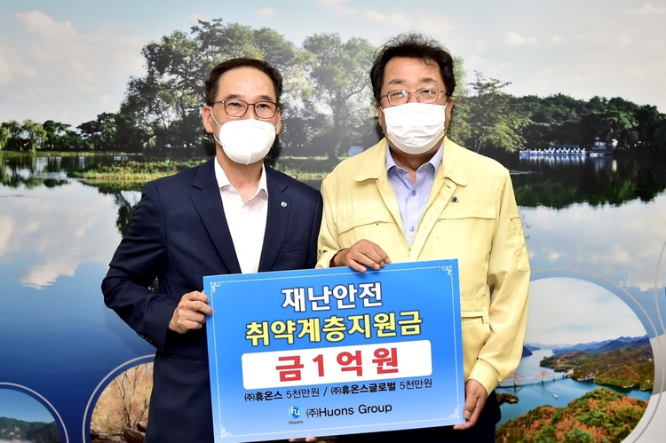 휴온스글로벌과 휴온스가 제천시에 수해 복구 지원금 1억원을 기탁했다. 휴온스 전규섭 부사장(왼쪽)과 이상천 제천시장(사진=휴온스그룹)