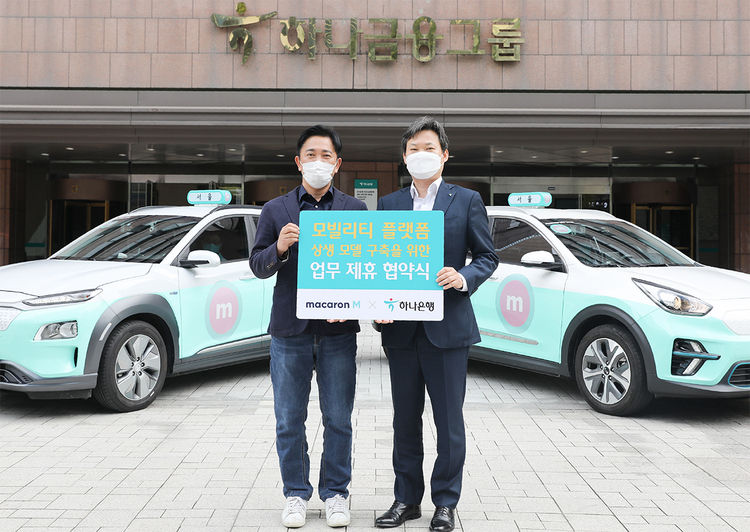 하나은행은 지난 13일 서울 중구에 위치한 하나금융그룹 명동 본점에서 모빌리티 산업을 성장시키는 상생 모델 구축을 위한 업무협약을 체결했다. 이행열 케이에스티모빌리티 대표(사진왼쪽)와 이장성 하나은행 플랫폼금융사업TFT 본부장이 마카롱택시 앞에서 기념촬영을 하고 있다.
