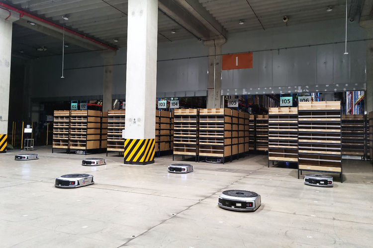AGV(고정노선 이동로봇)가 선반랙 및 주문 상자를 작업자에게 이송해 피킹, 검수, 포장 업무를 지원하는 시스템