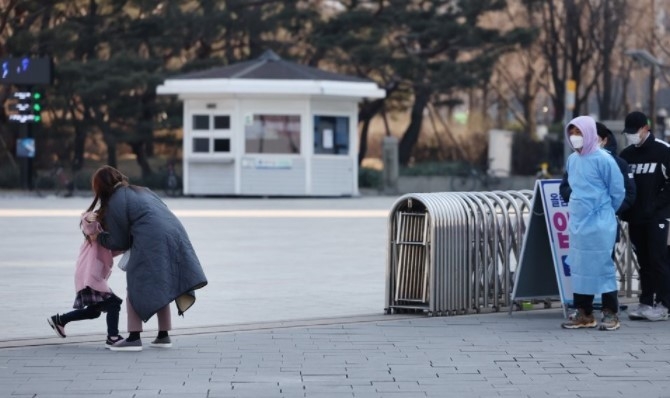 지난 10일 올림픽공원 평화의문 앞에 마련된 코로나19 임시 선별검사소에서 아이와 함께 신속항원검사를 기다리던 여성이 '무섭다'며 달아나려 안간힘을 쓰는 아이를 설득하고 있다. 